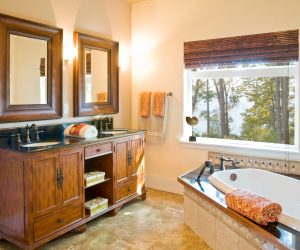 Luxury master bath bathroom with wood cabinets, tile floor and bathtub surround, soaking tub and twin sinks with high quality fixtures in upscale home interior
